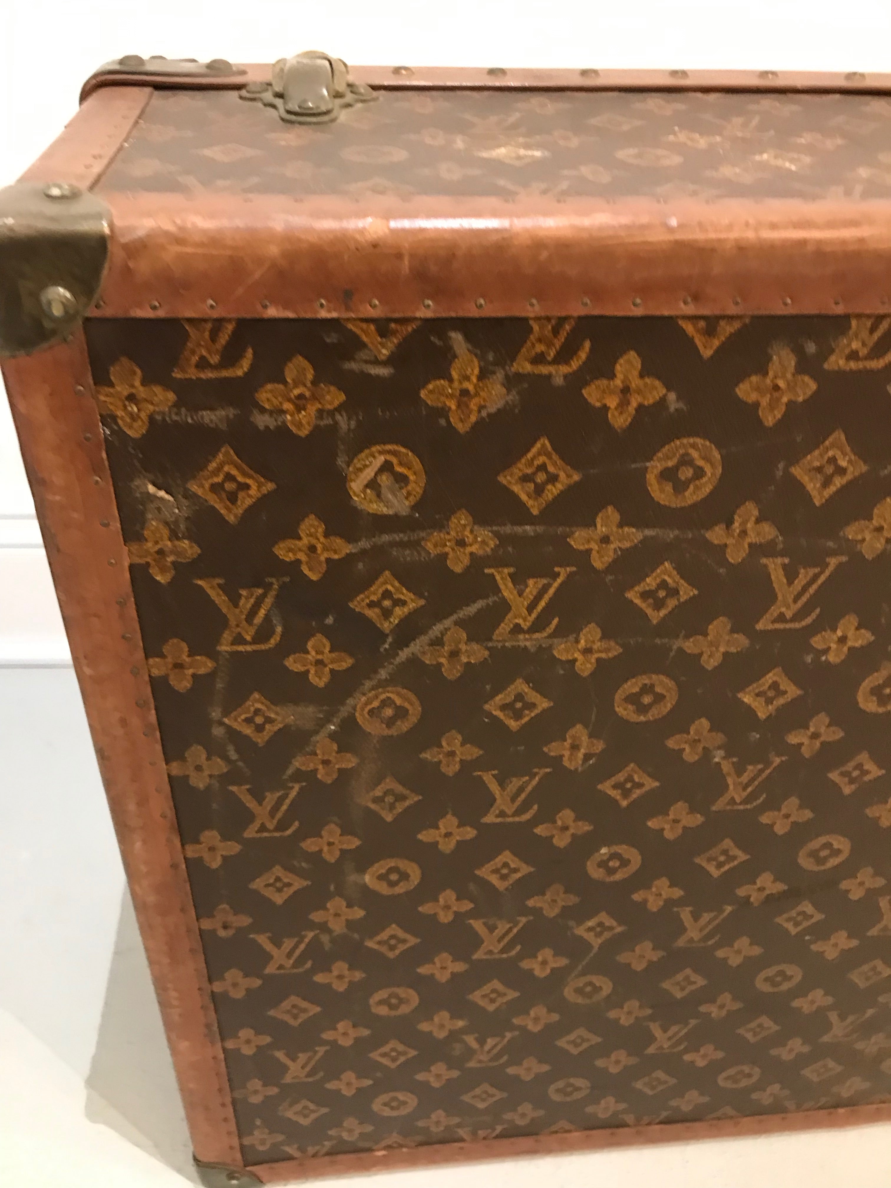 A vintage Louis Vuitton suitcase for sale in an antique shop in
